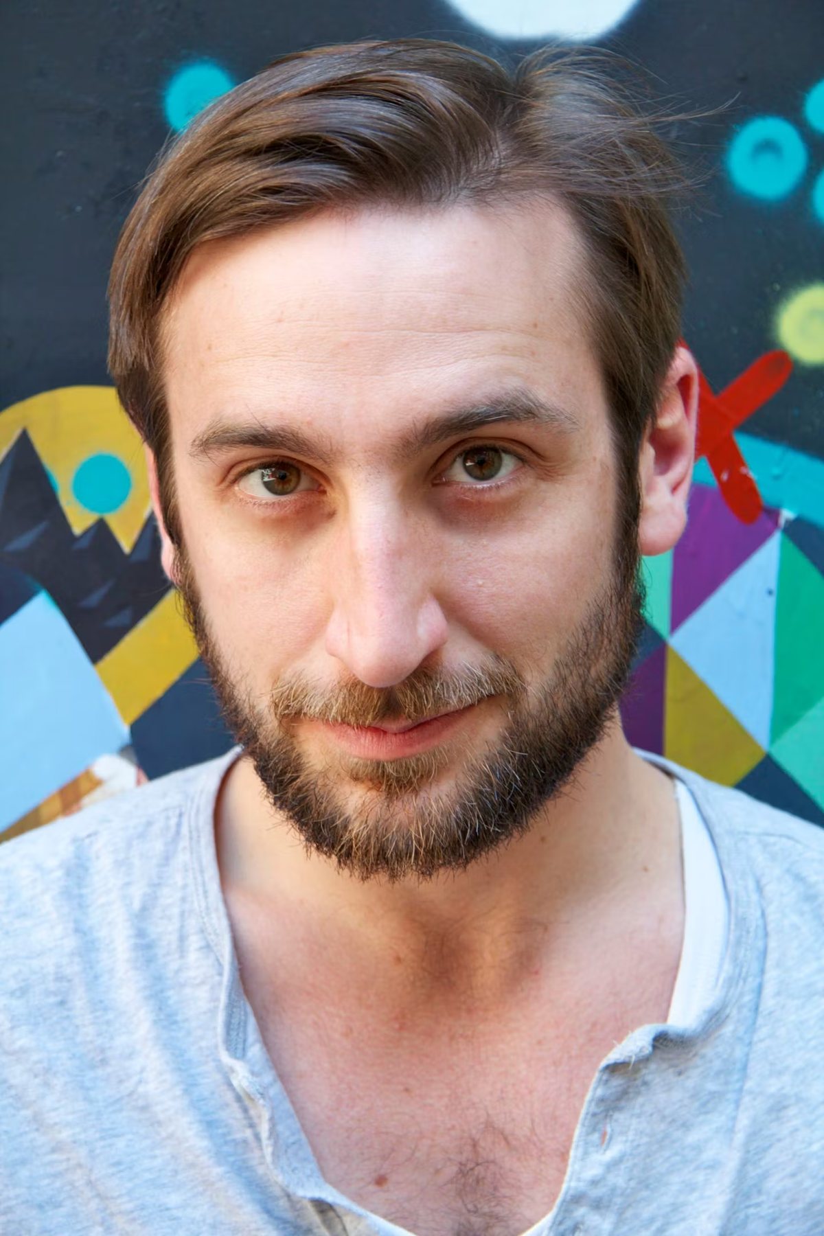 Portrait von Walter Schmuck vor einer bunten Graffitiwand